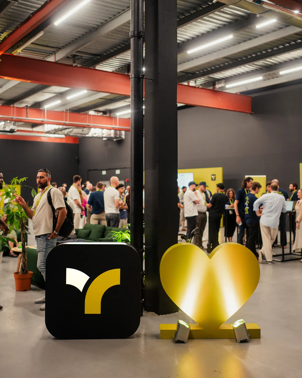The Teya logo cube and a gold heart sculpture at a Teya event.