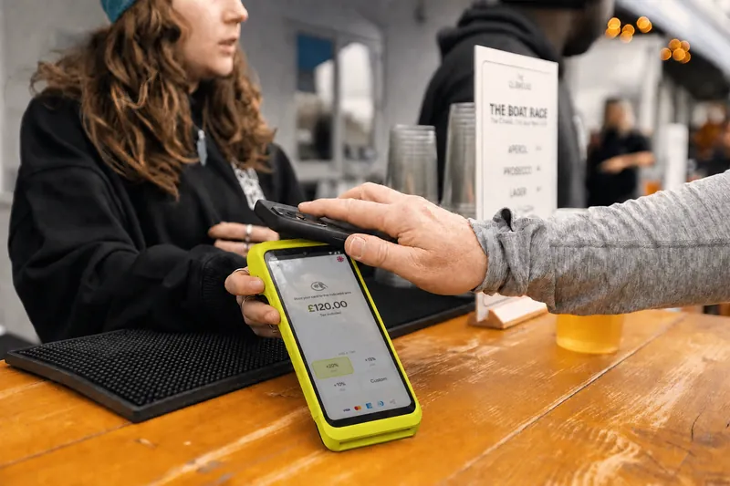 A barista handing Teya Pro across a wooden counter